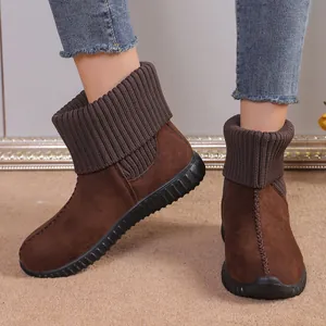 Detail shot of brown suede snow boots with knitted cuffs and flat rubber soles