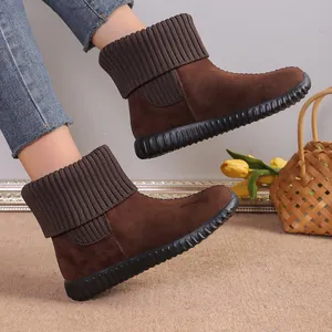 Close-up of stylish brown suede snow boots with cozy knit collar detail on model's feet