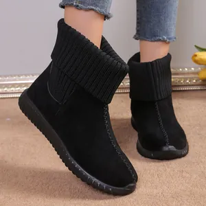 Close-up of women's black snow boots with knitted cuffs and textured flat soles