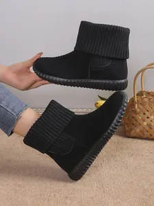 Close-up view of black winter snow boots featuring a knit collar and slip-resistant sole