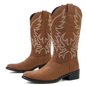 Close-up detail of brown men's western cowboy boots with white wing-style embroidery