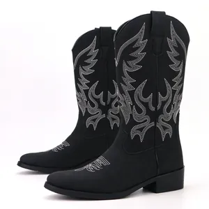 Detailed view of men's black vintage Western cowboy boots with white embroidery patterns.