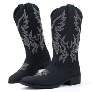 Detailed view of retro black men's cowboy boots featuring intricate white wing embroidery.