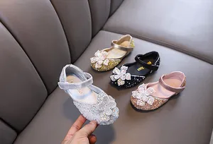 Detailed view of sparkly rhinestone princess shoes with large flower accents for girls