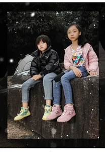 Bambini che indossano eleganti stivali invernali rosa e gialli in un ambiente esterno