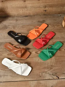 Draufsicht auf flache Sandalen mit eckiger Zehenpartie in sechs Farben auf Holz