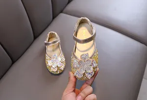 Detail view of gold rhinestone girl's princess shoes with crystal flower ornament