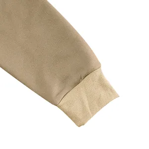 Close-up detail of khaki sweatshirt sleeve showing ribbed cuff and fabric texture.