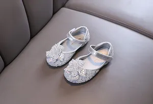 Detailed view of silver sparkly girl's Mary Jane shoes with crystal flower decoration