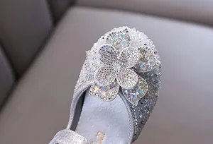 Detailed close-up of the sparkling rhinestone flower on a silver princess shoe for girls