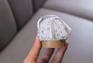 Detailed view of silver rhinestone and pearl embellishments on girls princess shoes