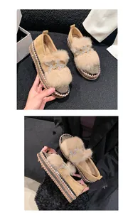 Detailansicht der beigen Plateau-Loafer mit Strass-Schmetterling und Kunstpelzbesatz.