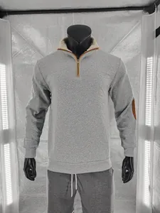 Detail view of men's gray quarter-zip sweatshirt with warm fleece collar and elbow patches