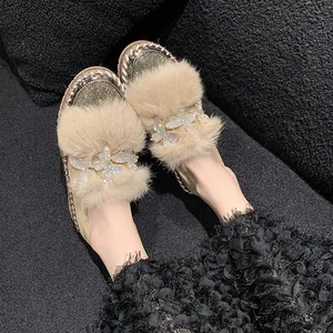Modische beige Plateau-Loafer mit flauschigem Pelzbesatz und Strass-Schmetterlingsdetails.