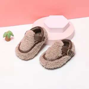 Primer plano de zapatos de sherpa marrón para bebé con correa de hebilla de cuero