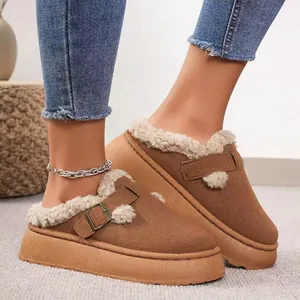 Primer plano de zapatillas marrones de plataforma con forro de felpa y hebilla.