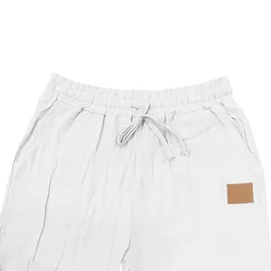 Detailed macro view of the drawstring elastic waist on white men's linen casual pants
