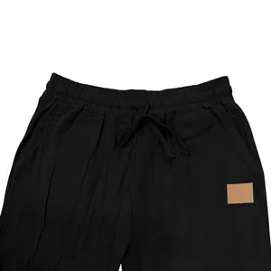 Detailed view of black men's linen pants featuring drawstring waist and side patch