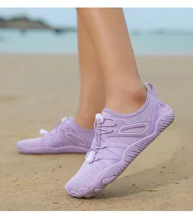 Detailed shot of light purple wading shoes worn on a sandy beach for water sports