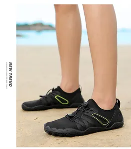 Close-up of black barefoot wading shoes worn on a sandy beach