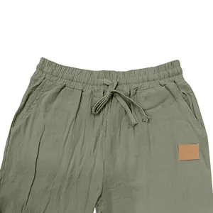 Detailed view of the drawstring elastic waistband on men's green linen casual shorts