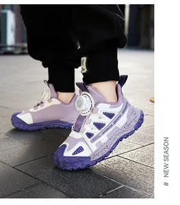 Close-up of children's purple sneakers with rotary buckle dial system on outdoor pavement.