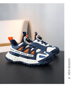 Detail view of navy blue and orange children's sneakers with a rotary buckle system.