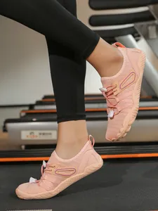 Breathable pink water shoes for yoga and fitness training on a treadmill background
