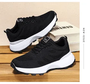 Seitenansicht schwarzer atmungsaktiver Mesh-Sneaker mit dicken weißen Sohlen auf Holz