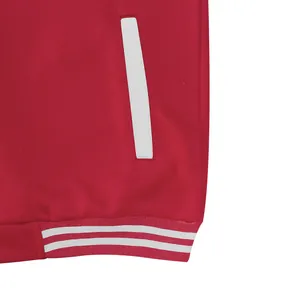 Detailopname van rood varsity jack met witte zak en gestreepte geribbelde zoom.