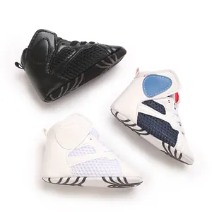 Detailed macro view of three multi-colored infant mid-top soft-sole walking sneakers