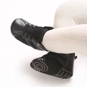 Close-up detail of black infant high-top walking shoes featuring soft non-slip rubber soles