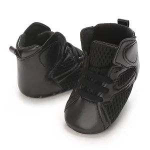 Close-up view of black baby mid-cut casual shoes featuring soft soles and breathable mesh panels