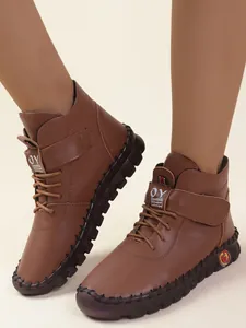 Gedetailleerd overzicht van bruine winterlaarzen met veter- en klittenbandsluiting.