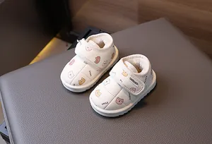 Detailed view of white toddler snow boots with cute bear patterns and plush lining