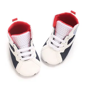 Close-up top-down view of navy blue and white infant mid-top leisure shoes with soft soles.