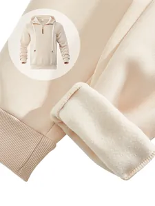 Detail des weichen Fleece-Futters und der Rippbündchen an einem beigen Kapuzenpulli.