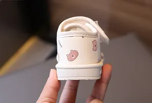 Close-up detail of the heel and sole on white toddler snow boots with cartoon bear patterns