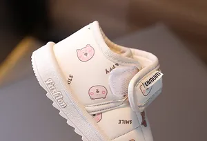 Close-up of baby snow boot showing pink bear pattern and Velcro strap detail