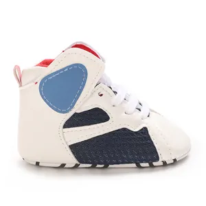 Close-up of white baby walking shoe with breathable navy mesh and soft sole