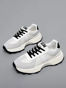 Vista dettagliata di sneaker in pelle bianca e grigia con spesse suole crema.