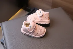 Close-up detail of pink fleece-lined baby winter snow boots with cute cartoon bear prints