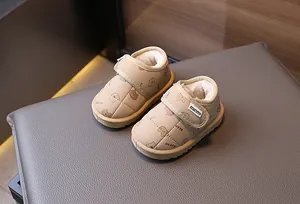Close-up of warm beige children's snow boots with soft fleece lining and bear pattern