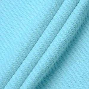 Close-up macro shot of light blue waffle knit fabric texture for men's polo shirt