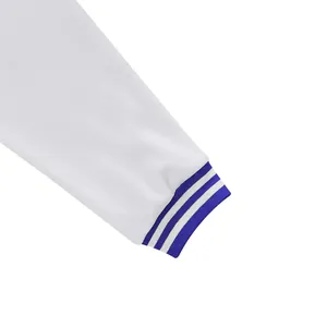 Detailopname van een witte jasmouw met blauw gestreepte geribbelde manchetdetails
