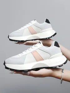 Dettaglio delle sneakers platform in pelle bianca con strisce rosa per donne e bambini.
