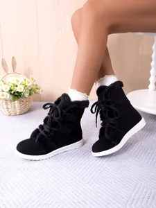 Cozy warm black faux fur lined snow boots with lace-up design and white rubber flat soles.