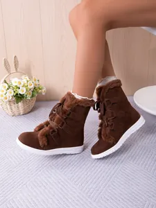 Detailed view of brown lace-up women's snow boots with soft faux fur trim for winter.