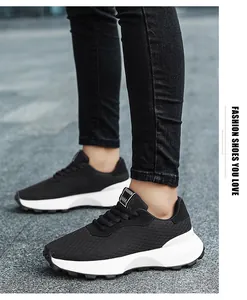 Close-up of black breathable mesh sneakers with chunky white soles on pavement