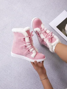 Detailed view of pink faux fur lined snow boots with lace-up design for winter.